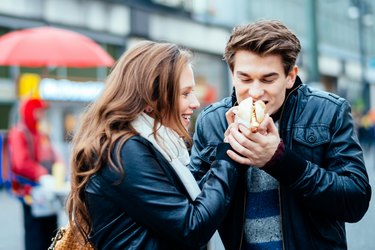 A couple eating a hot dog together