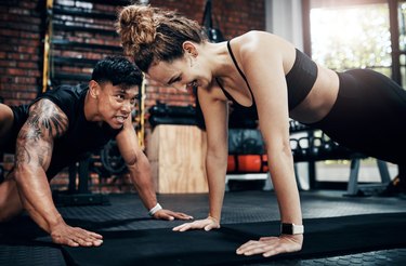 Woman holding plank with trainer