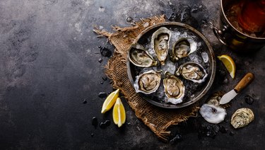 Open Oysters with lemon and Rose Wine in ice bucket