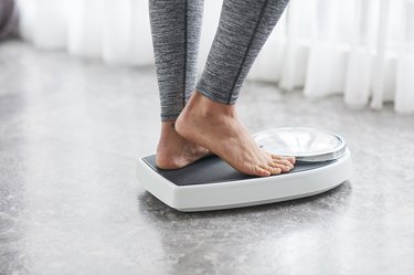 Young healthy girl on home scales