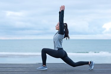 美丽的黑发女人在海滨穿着运动服