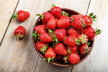 Fresh strawberry in a clay plate  on wooden table