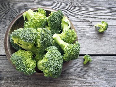 Raw broccoli on wooden background, as an example of foods that cause body odor