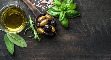 Green and black Mediterranean olives in old cooking spoon