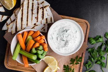 Yogurt Tzatziki sauce with parsley served with fresh carrot and celery sticks