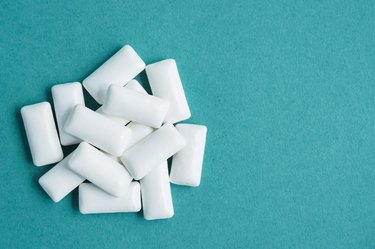 top view of heap of chewing gums on blue background, copy space