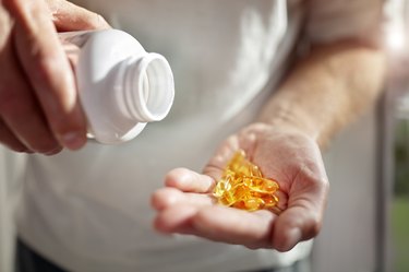 A man pouring a bottle of vitamin d supplements into his hand