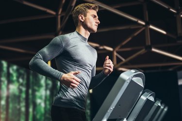 Man running a HIIT treadmill workout at the gym