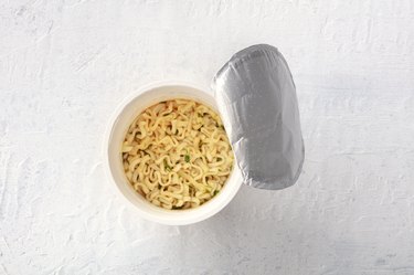 Plastic cup of instant ramen noodles, shot from the top with a place for text