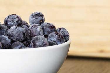 white bowl full of frozen blue berries