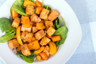 tofu sweet and sour with bell peppers over spinach bed
