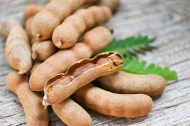 Tamarind and leaves tropical fruit - Sweet tamarind on wooden background