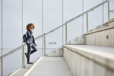 Businesswoman using smart phone on steps