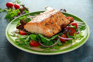 Baked niacin-rich salmon steak on a bed of leafy greens.