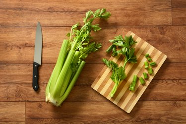 Celery cut with knife and chopping board