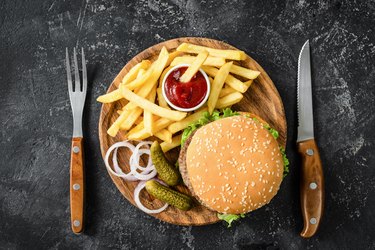 Beef burger, french fries, pickles, onion and ketchup