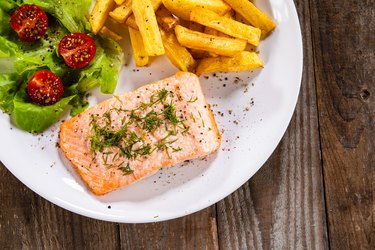 Grilled salmon with French fries and vegetable salad