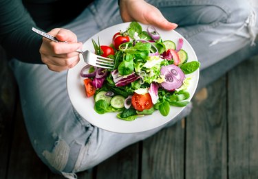 Fresh salad in hands view from above