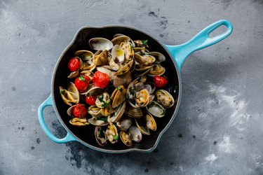 Vongole Seafood Clams with tomatoes and parsley in frying cooking pan