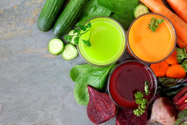 Three types of healthy vegetable juice, above view on slate