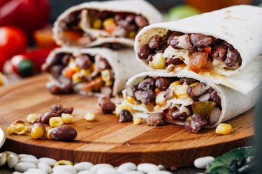 Vegetarian burrito over black table on wooden board for vegan breakfast recipes