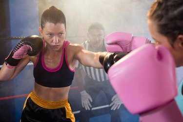 Female athletes fighting in boxing ring