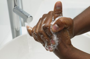 close up of Black person washing hands