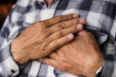 close view of a person holding their chest because they have a racing heart