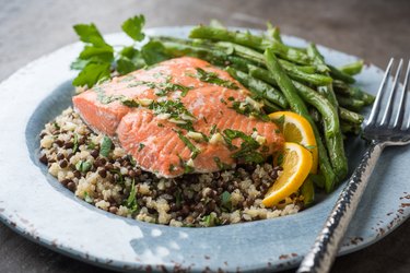 A plate of salmon over quinoa with green beans on the side