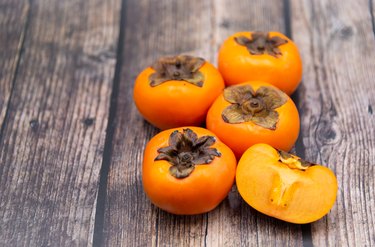 Persimmon fruit on old wooden background, Top view.