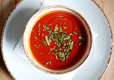 Tomato and basil soup on a white plate compatible with low-carb diet