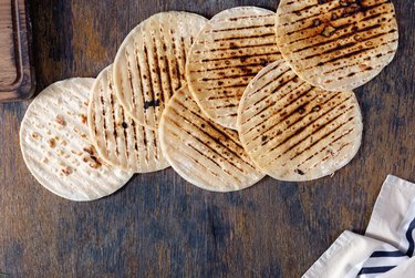 Set of tortillas cooked on a grill on a wooden table