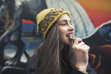 Image of a young woman biting a chocolate bar