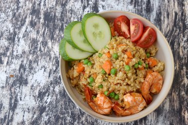 Nasi Goreng Udang. Indonesian fried rice with prawns, egg, pea, carrot, tomato and cucumber