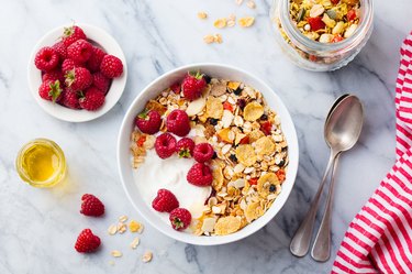 Healthy breakfast. Fresh granola, muesli with yogurt and berries on marble background. Top view.
