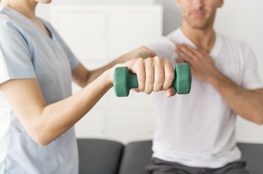 Patient at the physiotherapy doing physical exercises with his therapist