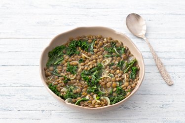 Stewed kale lentils with onions and garlic on a light background