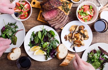 top view of a table filled with plates of various foods