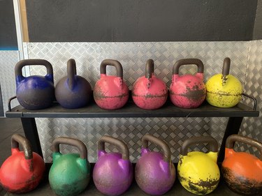 Kettlebells of different colors at the gym on rack