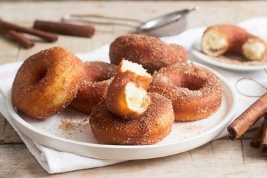 Homemade donuts with sugar and cinnamon on a wooden background. Rustic style.