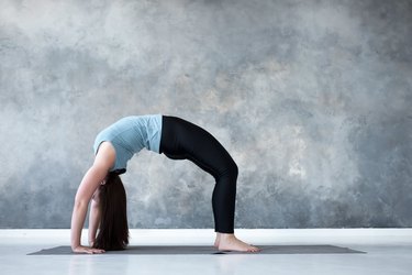 Young Attractive Woman in Viparita Karani Pose, Studio Backgroun