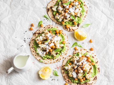 Gluten free flatbread with roasted chickpeas, cauliflower and avocado dip on a light background, top view. Healthy vegetarian food concept. Flat lay
