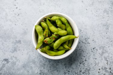 Fresh steamed Edamame soybean pod with spice on concrete background