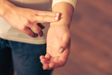 Woman checking pulse on wrist closeup