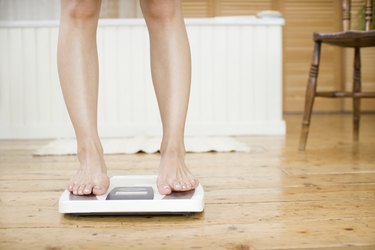 Woman weighing herself on a bathroom scale