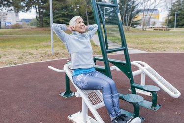 Mature Woman with Grey Hair Exercising at Outdoor Gym