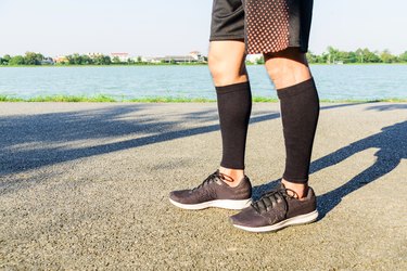 runner wear the compression sleeve and shoes, getting ready to strengthen his calves at home