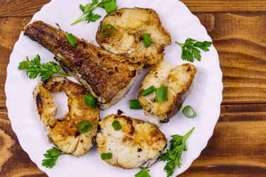 Roasted basa in white plate on a wooden table