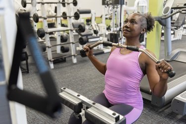 Mature woman weight training in gym