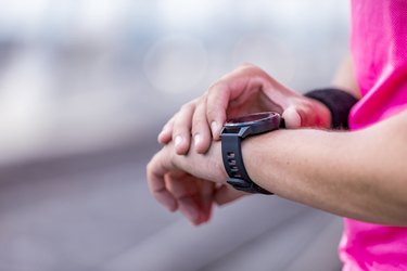 runner outside looking at heart rate monitor smartwatch